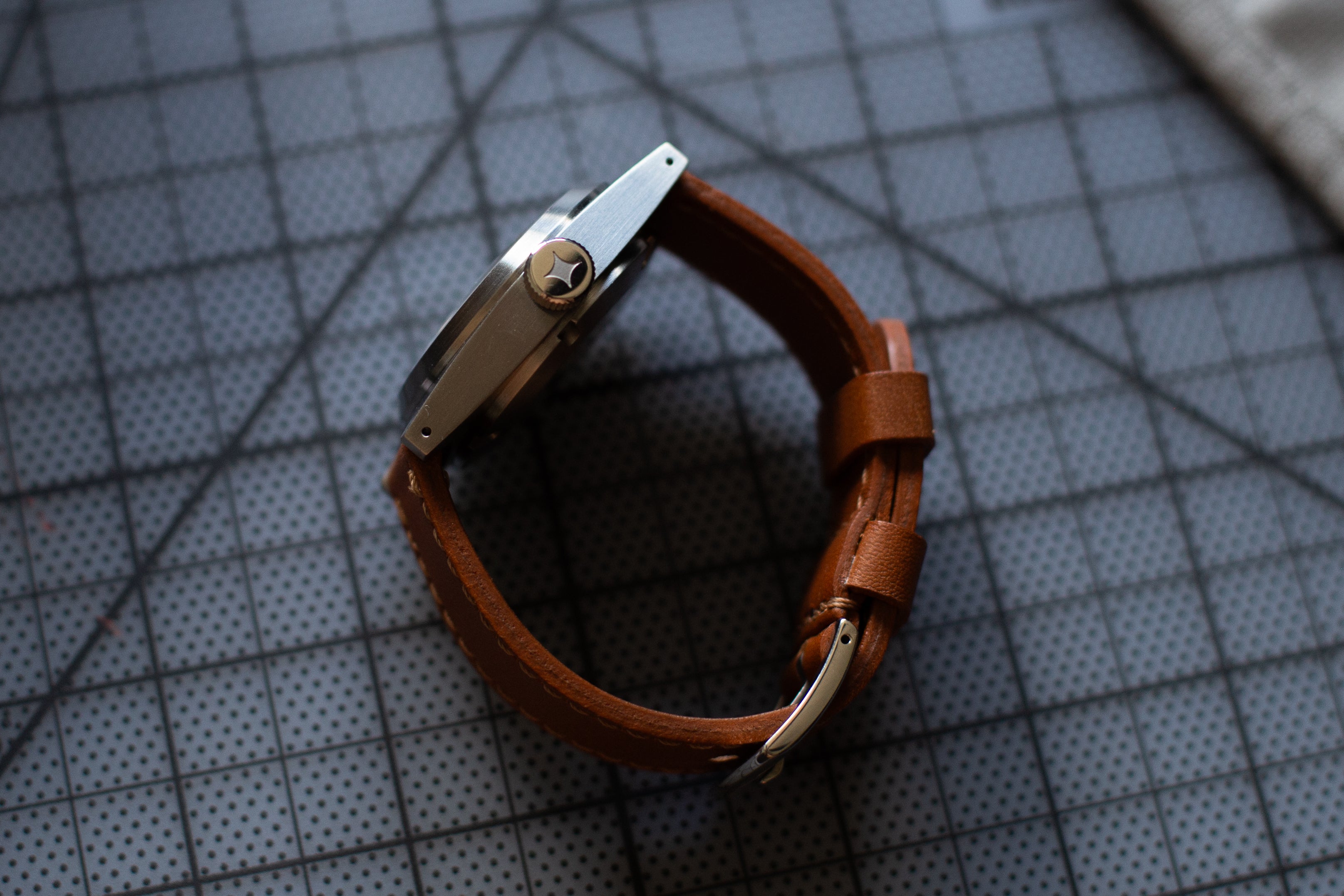 Brown leather watch strap on a textured surface